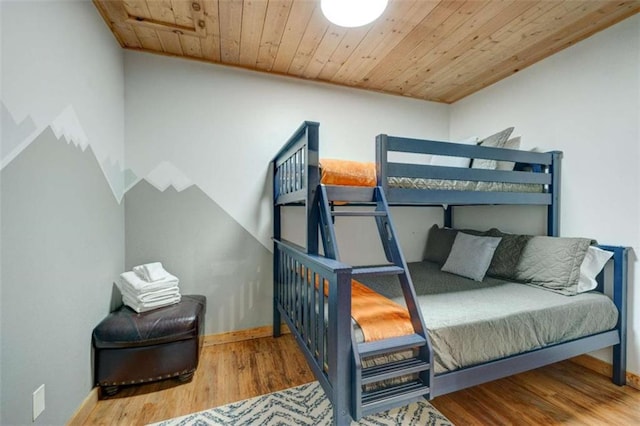 bedroom with wood ceiling, baseboards, and wood finished floors