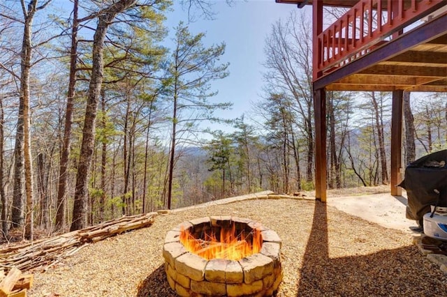 view of yard featuring a deck and an outdoor fire pit