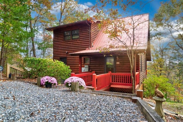 view of front of house featuring log veneer siding and metal roof