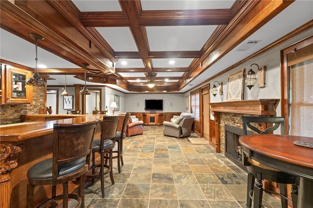 4840 Spring Park Cir, Suwanee, GA 30024 - dining space with a fireplace, coffered ceiling, beam ceiling, stone finish flooring, and ceiling fan