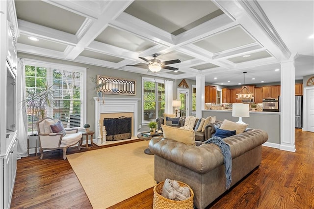4840 Spring Park Cir, Suwanee, GA 30024 - living room with ornate columns, dark wood finished floors, coffered ceiling, a ceiling fan, and a fireplace with flush hearth