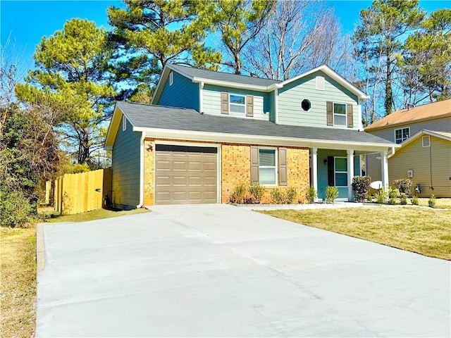 traditional-style home featuring brick siding, an attached garage, fence, driveway, and a front lawn