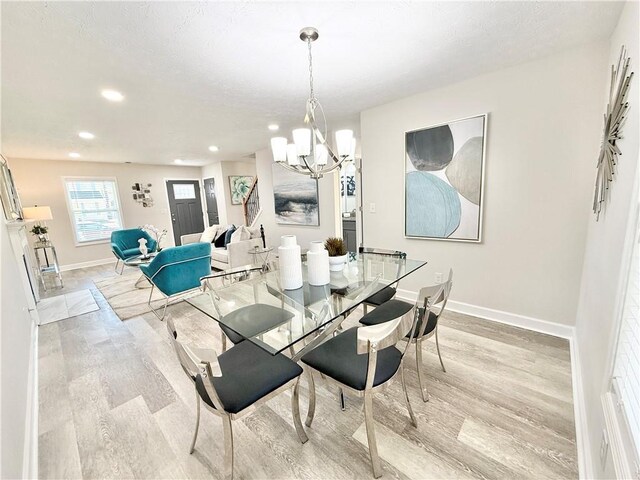 dining space featuring an inviting chandelier, baseboards, wood finished floors, and recessed lighting
