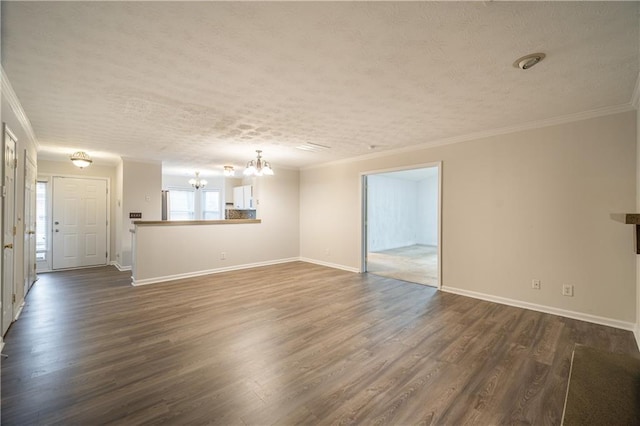 unfurnished living room with an inviting chandelier, ornamental molding, dark wood-type flooring, and a textured ceiling