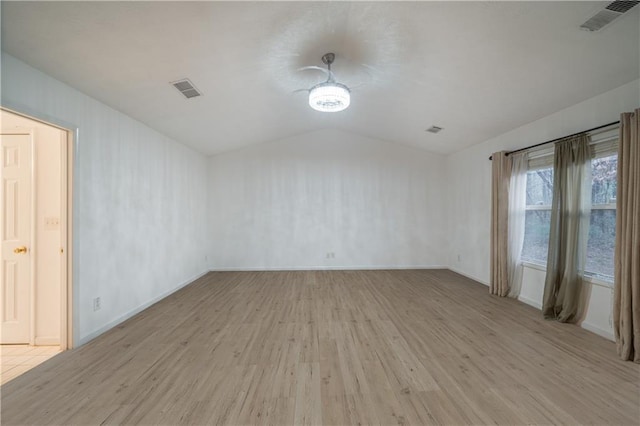 unfurnished room featuring lofted ceiling and light wood-type flooring