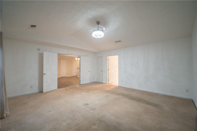 spare room with lofted ceiling and light colored carpet