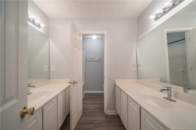 bathroom with hardwood / wood-style flooring, vanity, and a textured ceiling