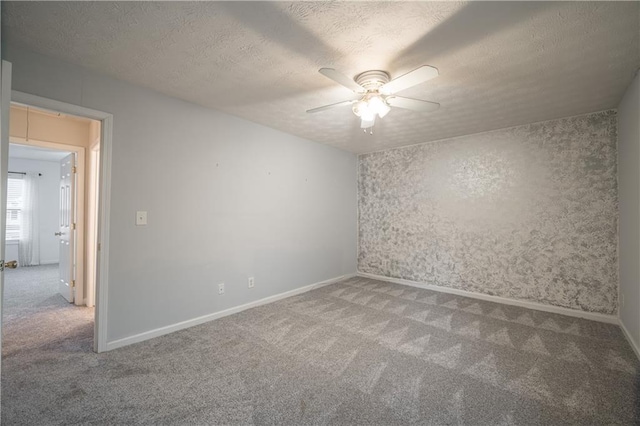 carpeted spare room with ceiling fan and a textured ceiling