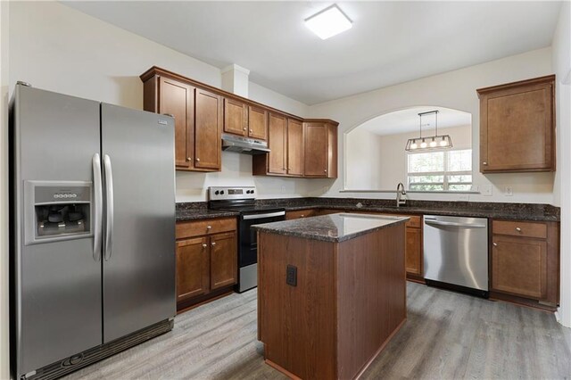 2957 Smith Ridge Trce, Peachtree Corners, GA 30071 - kitchen featuring appliances with stainless steel finishes, under cabinet range hood, light wood finished floors, a kitchen island, and dark stone counters