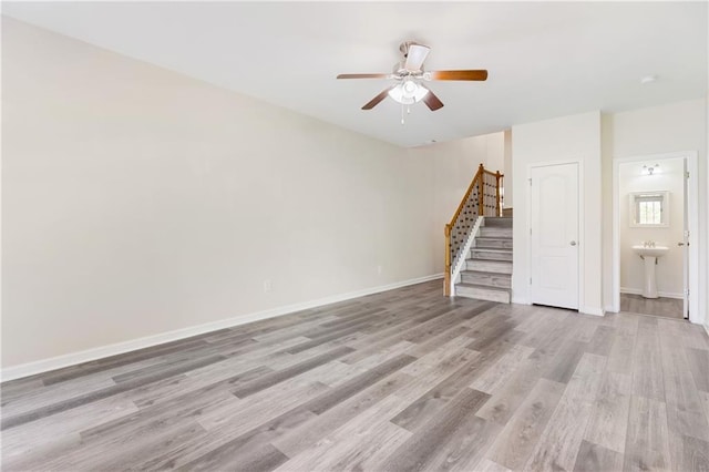 2957 Smith Ridge Trce, Peachtree Corners, GA 30071 - unfurnished living room with stairway, ceiling fan, light wood-style floors, baseboards, and a sink