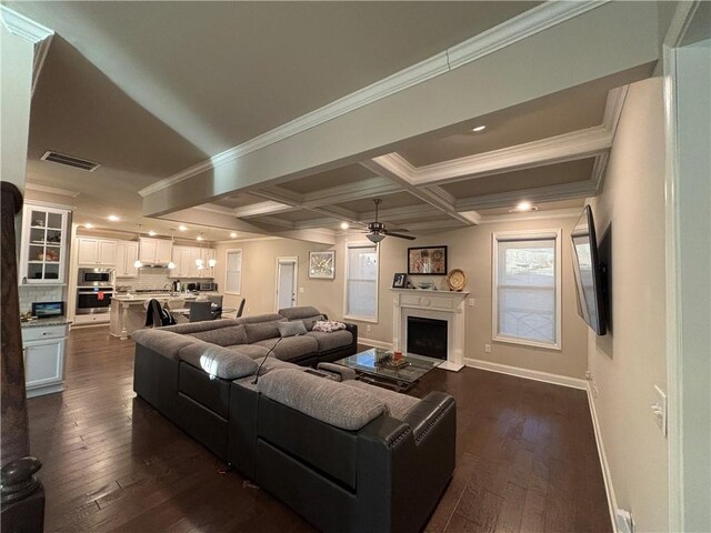 living area with coffered ceiling, dark wood-style flooring, visible vents, and a fireplace