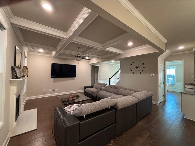 living room with coffered ceiling, crown molding, and dark hardwood / wood-style flooring