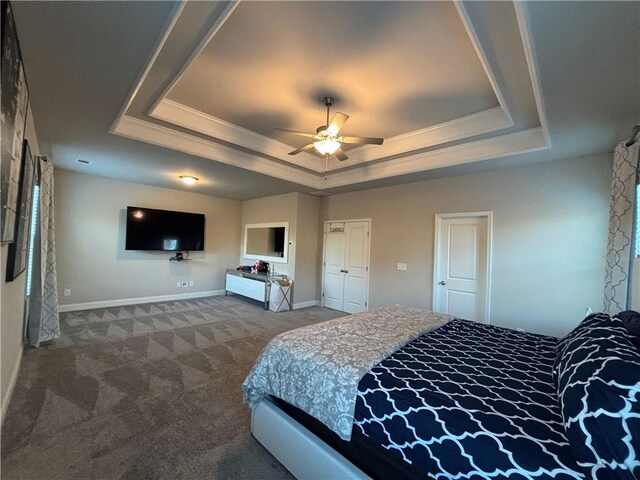 carpeted bedroom featuring multiple windows, crown molding, ceiling fan, and a tray ceiling