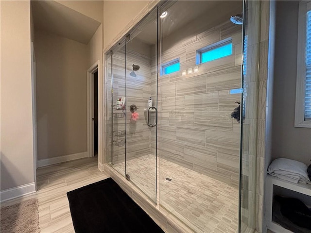 full bathroom featuring a stall shower and baseboards