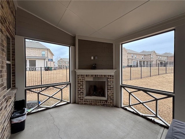 interior space featuring lofted ceiling, an outdoor brick fireplace, and a residential view