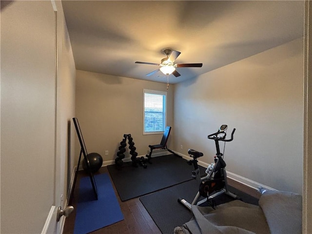 workout area with dark wood finished floors, baseboards, and ceiling fan