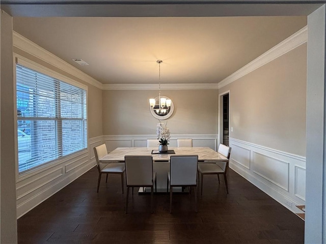 dining room with visible vents, a wainscoted wall, dark wood-style flooring, an inviting chandelier, and crown molding