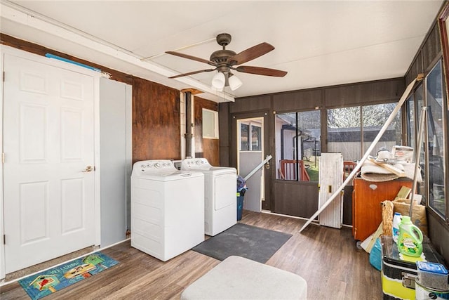 clothes washing area with washer and clothes dryer, laundry area, a ceiling fan, and wood finished floors