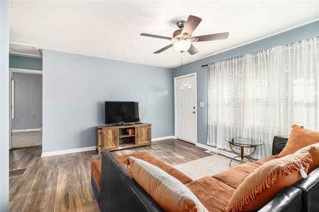 living area featuring wood finished floors, baseboards, and ceiling fan