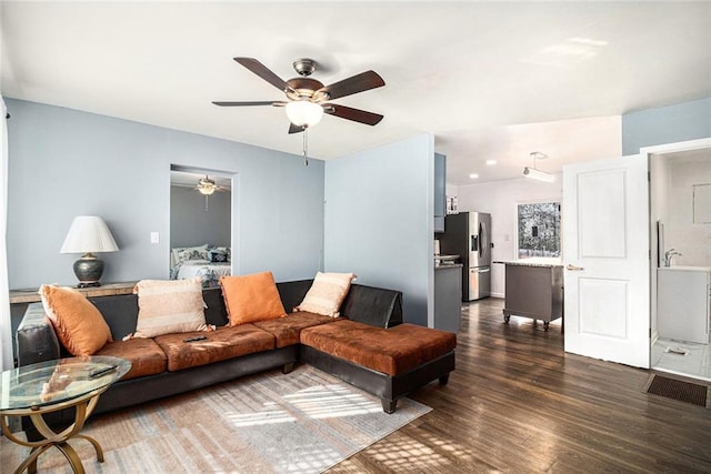 living room featuring dark wood finished floors and a ceiling fan