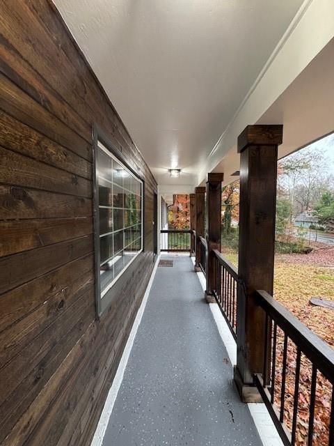 hallway featuring wood walls