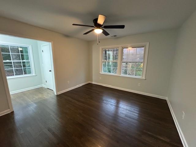 spare room with ceiling fan and dark wood-type flooring