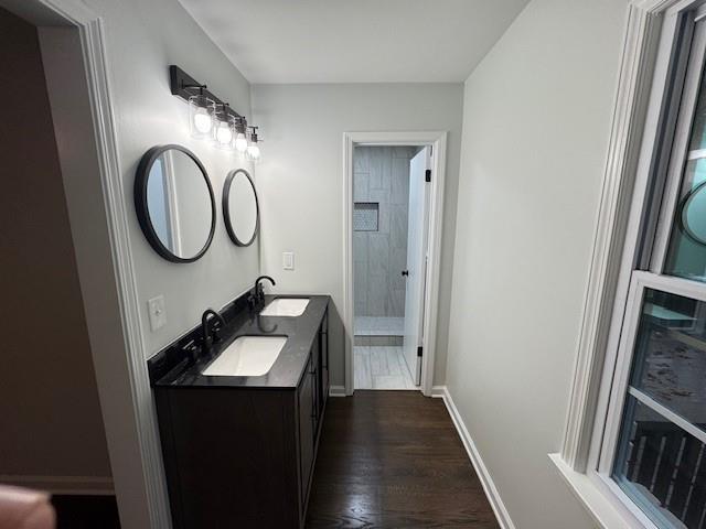 bathroom with wood-type flooring, vanity, and walk in shower