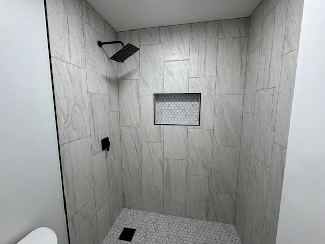 bathroom featuring toilet and tiled shower