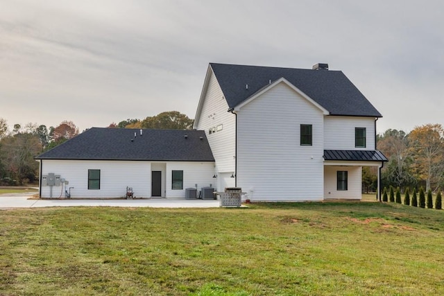 back of house featuring central AC unit, a yard, and a patio