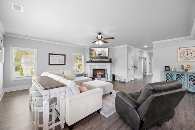 living room featuring crown molding, plenty of natural light, and dark wood-type flooring