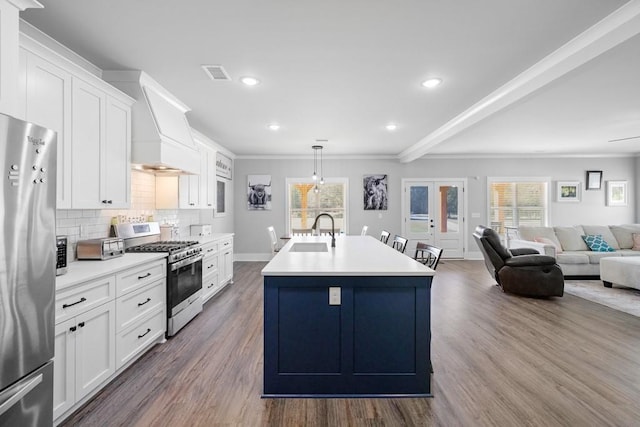 kitchen featuring appliances with stainless steel finishes, a center island with sink, plenty of natural light, and hardwood / wood-style flooring