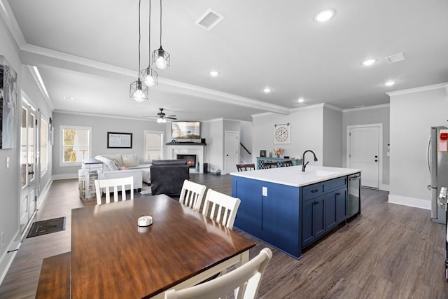 dining area with ceiling fan, crown molding, sink, and dark wood-type flooring