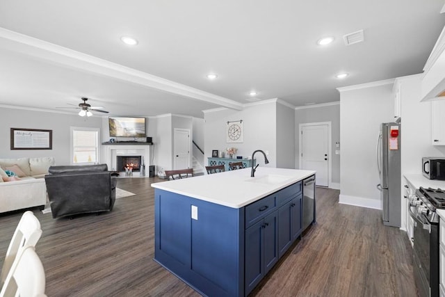 kitchen featuring blue cabinetry, sink, a kitchen island with sink, white cabinets, and appliances with stainless steel finishes