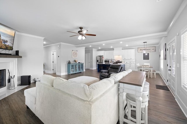 living room featuring dark hardwood / wood-style floors, ceiling fan, and ornamental molding