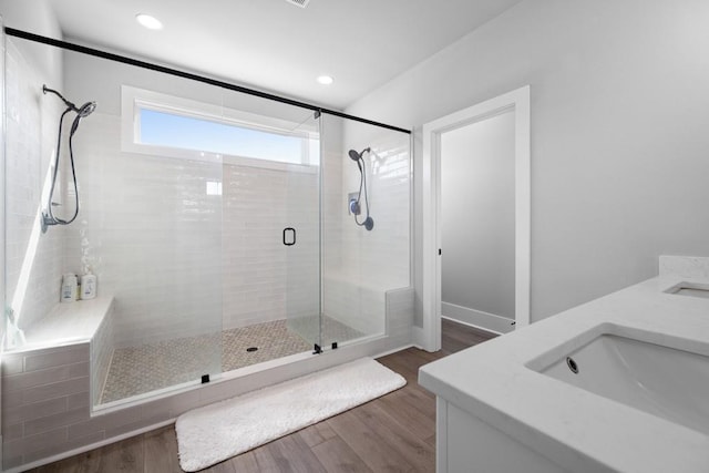 bathroom featuring hardwood / wood-style flooring, vanity, and a shower with door