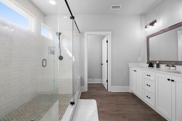 bathroom with a shower with door, vanity, and hardwood / wood-style flooring