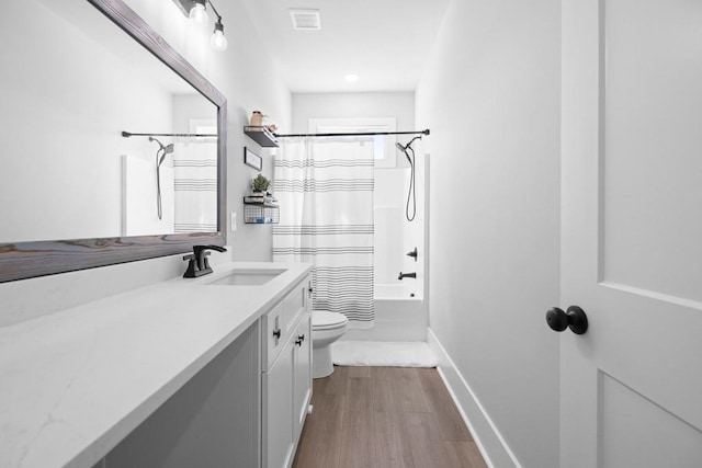 full bathroom featuring hardwood / wood-style flooring, vanity, toilet, and shower / tub combo with curtain