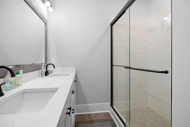 bathroom featuring hardwood / wood-style floors, vanity, and a shower with door