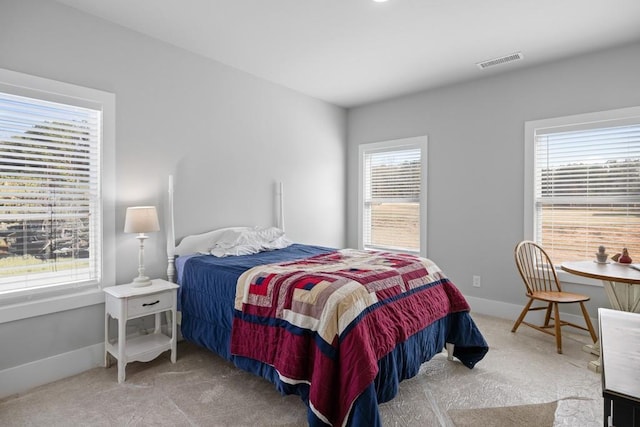 carpeted bedroom featuring multiple windows