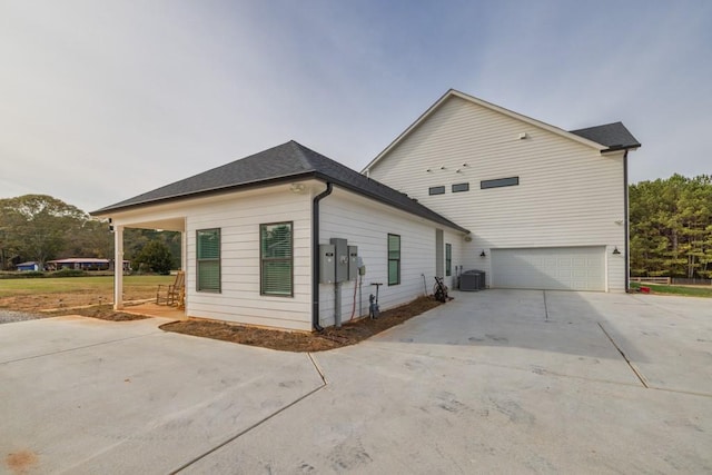 view of side of home featuring a garage and cooling unit