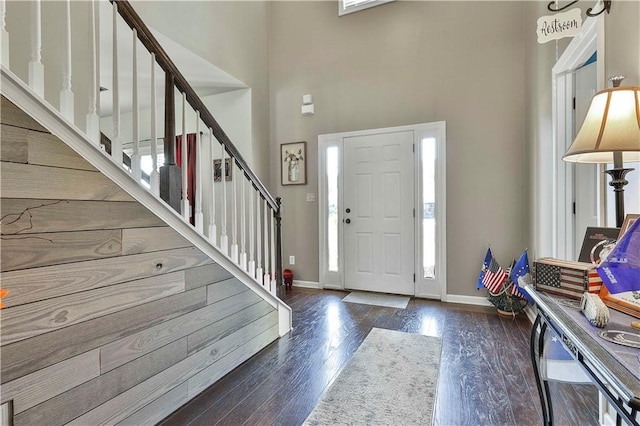 entrance foyer featuring dark hardwood / wood-style floors and a towering ceiling