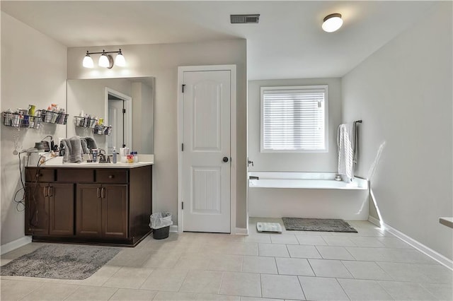 bathroom featuring a tub to relax in, tile patterned floors, and vanity