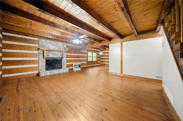 1975 Mack Rd, Douglasville, GA 30135 - unfurnished living room with a stone fireplace, wood-type flooring, wooden ceiling with exposed beams, and a ceiling fan