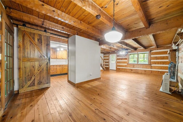 1975 Mack Rd, Douglasville, GA 30135 - unfurnished living room featuring wooden ceiling with exposed beams, light wood finished floors, wooden walls, and stairs