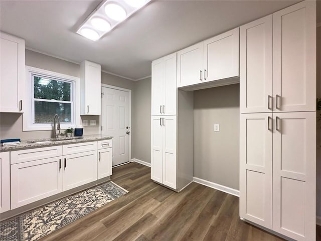 2068 Verbena St NW, Atlanta, GA 30314 - kitchen featuring light stone countertops, white cabinets, dark wood-type flooring, and crown molding