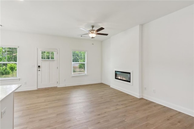 165 Mill Center Blvd Unit 108, Athens, GA 30606 - unfurnished living room featuring light wood finished floors, a ceiling fan, a glass covered fireplace, and baseboards