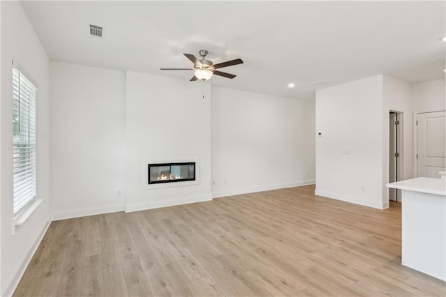 165 Mill Center Blvd Unit 108, Athens, GA 30606 - unfurnished living room featuring light wood finished floors, a glass covered fireplace, a ceiling fan, baseboards, and recessed lighting