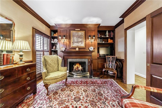 living area with crown molding, a fireplace, and built in shelves