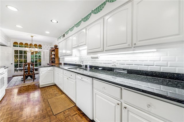 kitchen featuring white dishwasher, dark parquet floors, pendant lighting, dark stone counters, and white cabinets