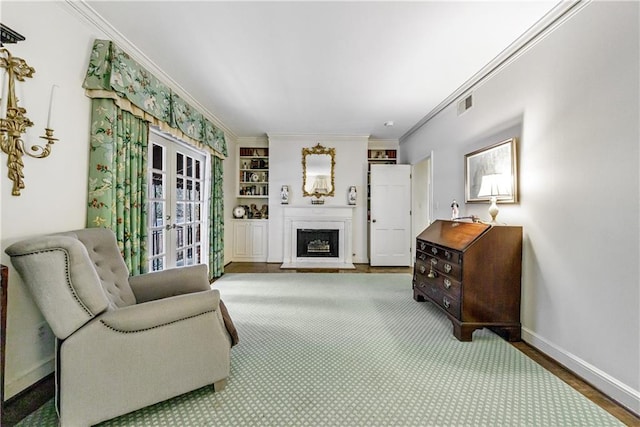 living room featuring crown molding, built in features, and french doors